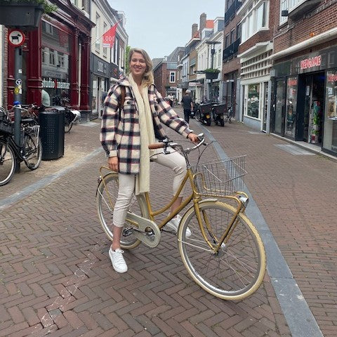Klant Rosanne op haar nieuwe Achielle Babette fiets in de kleur Mustard Gold Metallic in de Arnhemsestraat in Amersfoort.