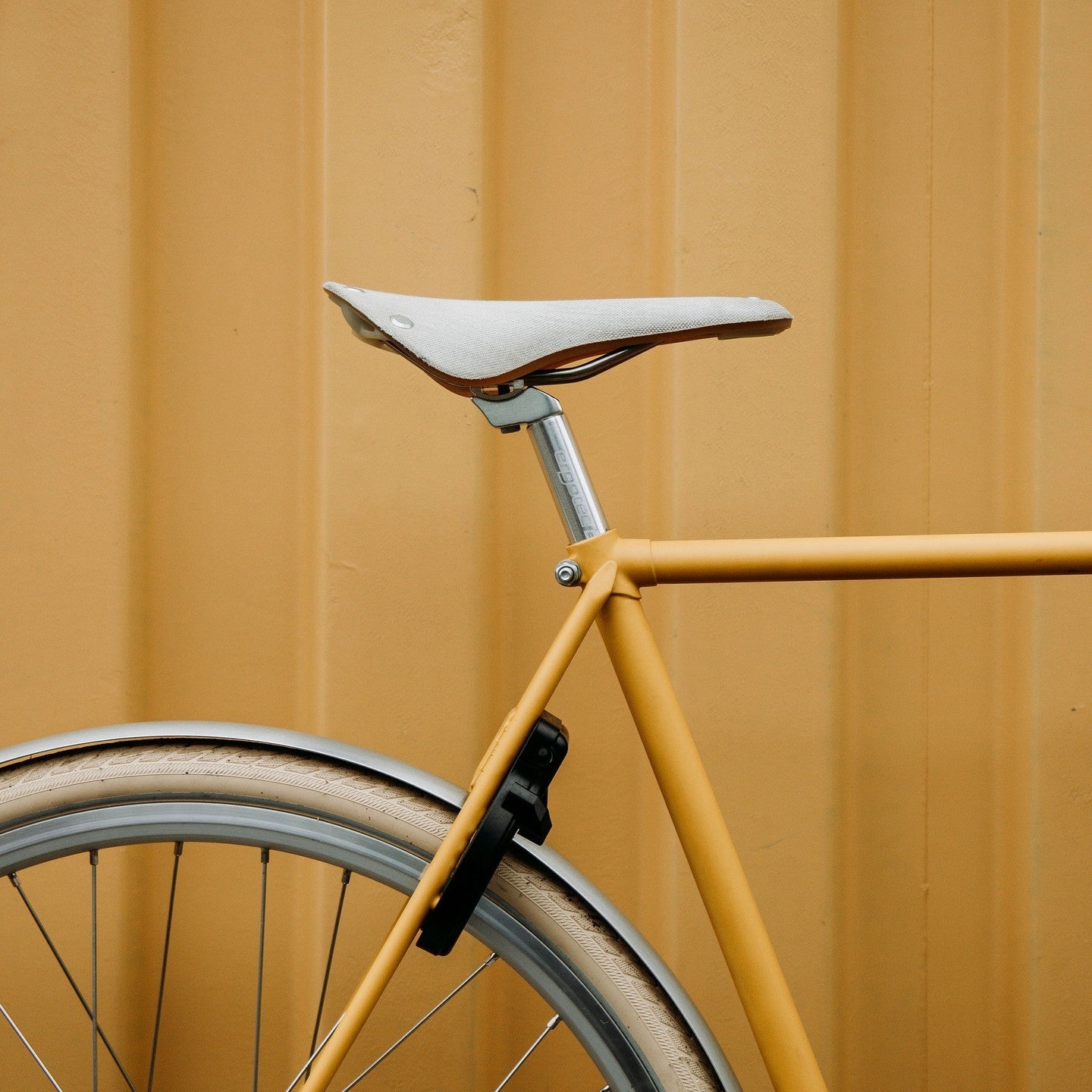 Een Roetz Vigour Men in de kleur Matt Rebel Yellow ingezoomd op de achterkant waardoor je het Brooks Cambium zadel goed kan zien