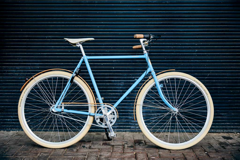 Roetz Vigour Men in de kleur Vintage Blue met houten spatborden met op de achtergrond een zwarte houten muur