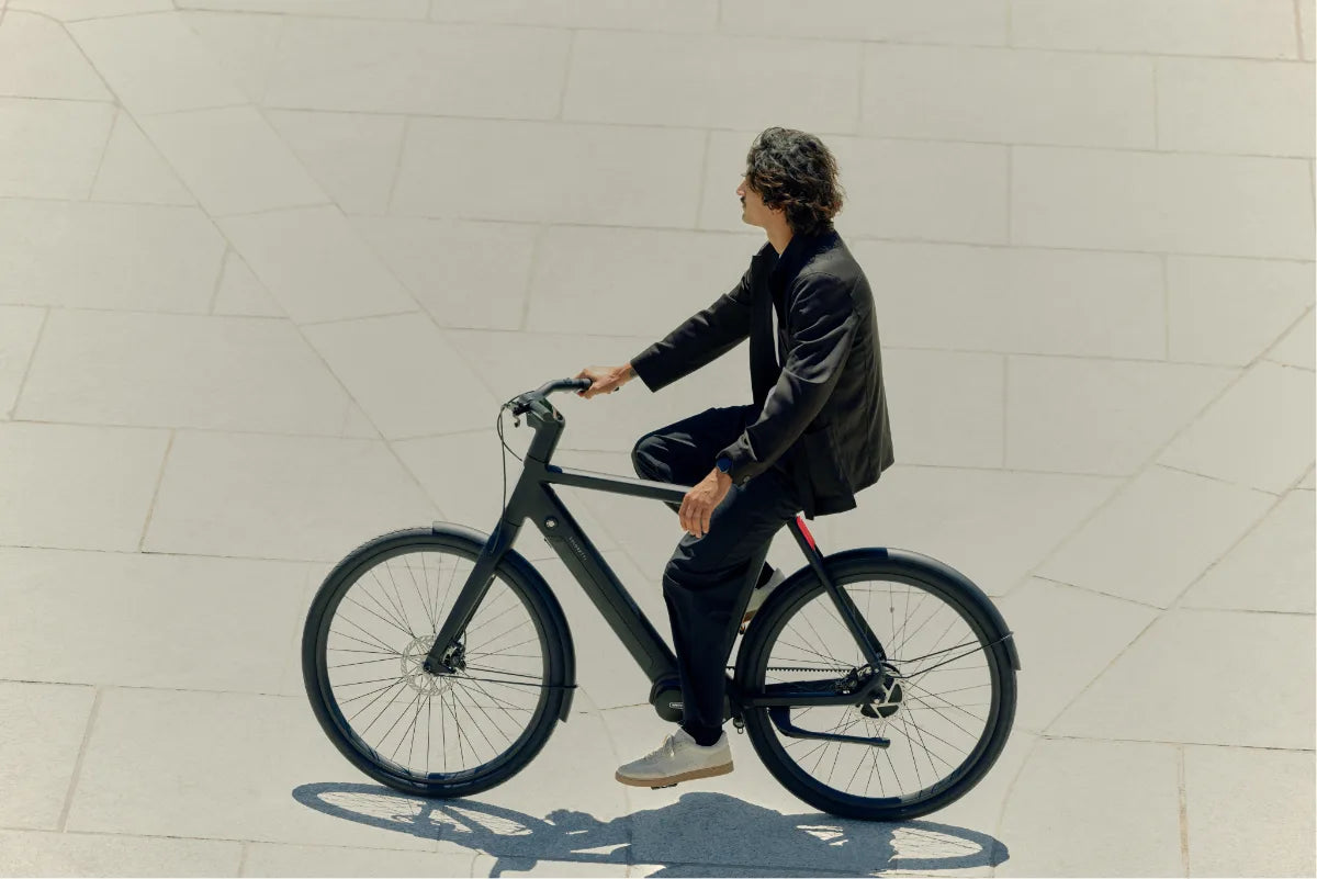 Een fietser op een VELORETTI Ace Two langs een lichte muur