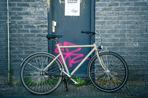 Een Brik Brut Heren fiets in de kleur Taupe met loesje poster "Ik lap de regen aan mijn laars"