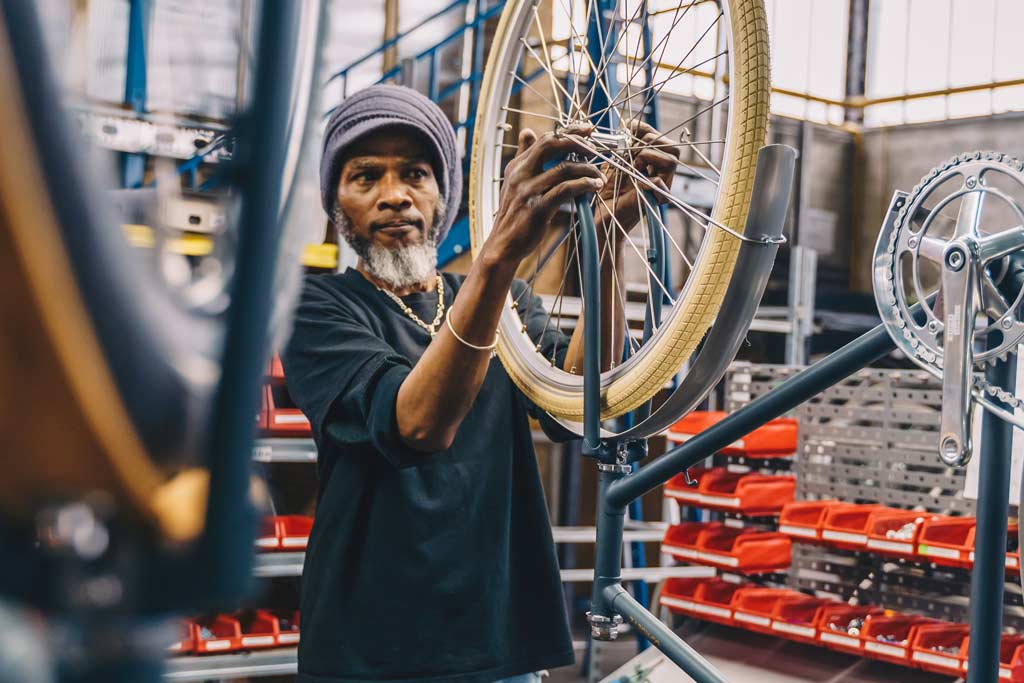 Sociale werknemer van de Roetz Fair Factory sleutelend aan een Roetz fiets.