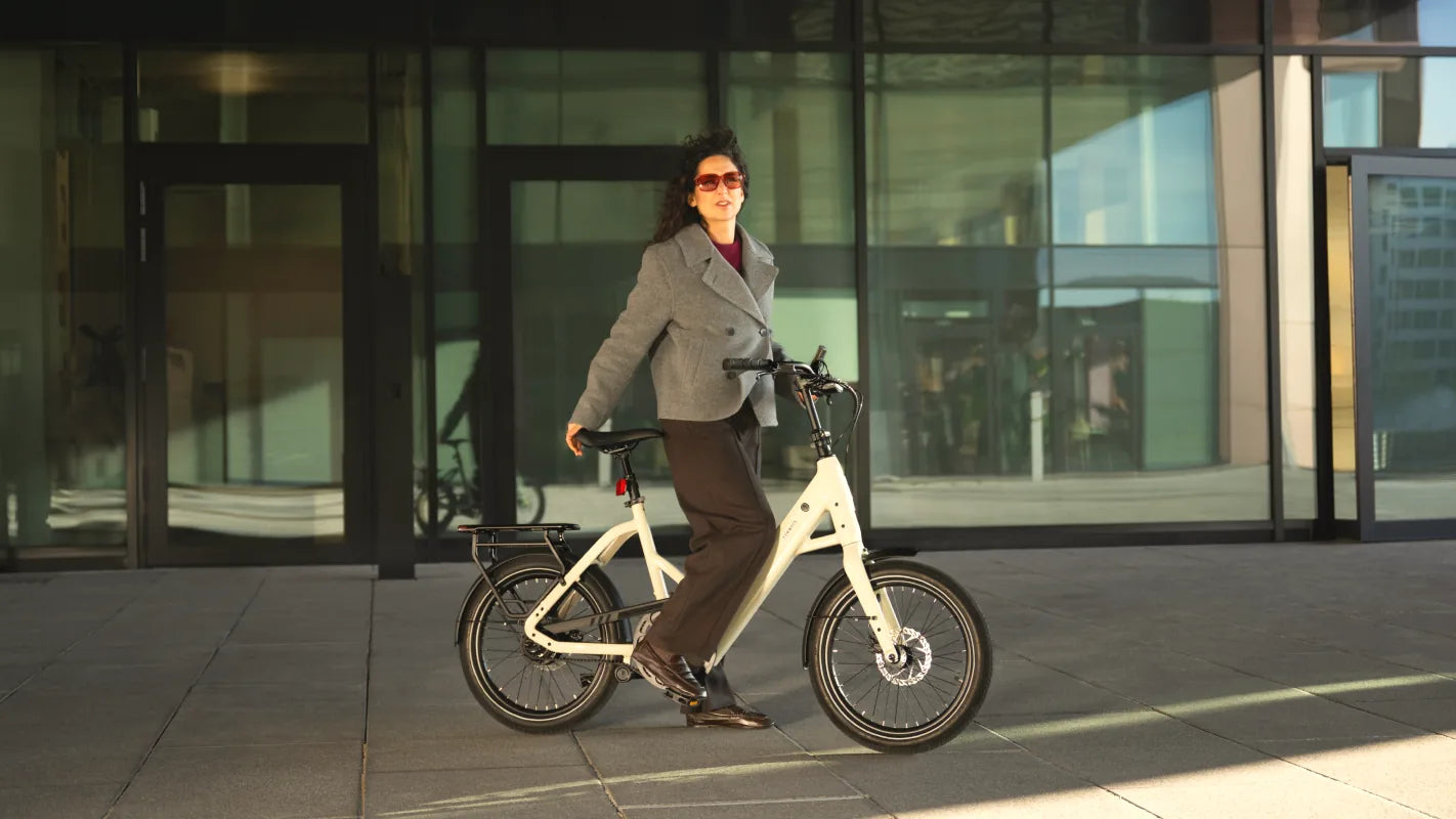 Een vrouw met zonnebril op een TENWAYS CGO Compact voor een glazen gebouw